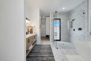 Bathroom with vanity and shower with separate bathtub