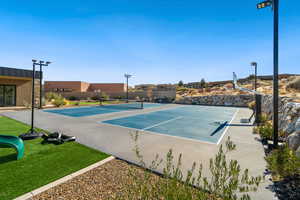 View of tennis court with basketball hoop