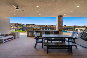 View of patio featuring a mountain view, grilling area, ceiling fan, and exterior kitchen