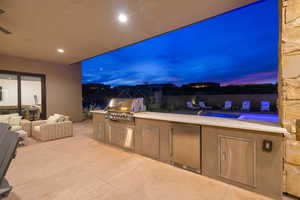 Patio terrace at dusk featuring area for grilling