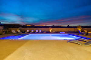 Pool at dusk with a patio area