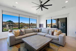 Living room with wood-type flooring and ceiling fan