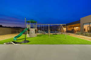 Playground at dusk with a lawn