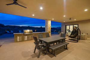 Patio terrace at dusk featuring a mountain view, an outdoor kitchen, and a grill