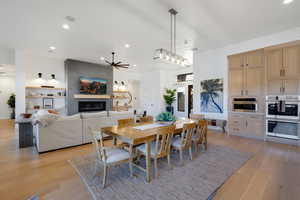 Dining area featuring ceiling fan, a fireplace, and light wood-type flooring