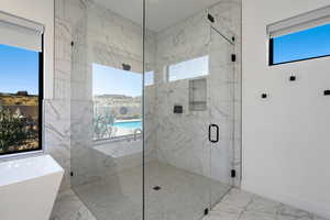 Bathroom featuring separate shower and tub and a wealth of natural light