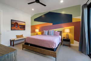 Bedroom with ceiling fan, light carpet, and vaulted ceiling