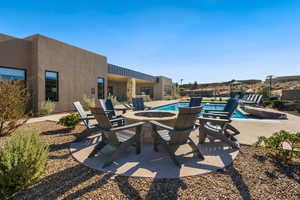 View of patio featuring a fenced in pool and an outdoor fire pit