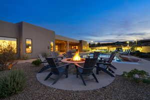 Patio terrace at dusk with a fenced in pool and an outdoor fire pit