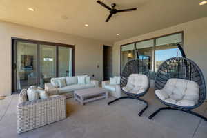 View of patio with ceiling fan and an outdoor hangout area