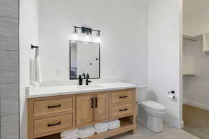 Bathroom featuring tile patterned flooring, vanity, and toilet