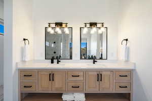 Bathroom featuring hardwood / wood-style floors, vanity, and walk in shower