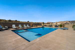 View of pool with a mountain view and a patio area