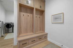 Mudroom with washing machine and clothes dryer and light hardwood / wood-style floors