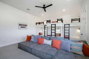 Carpeted living room featuring ceiling fan