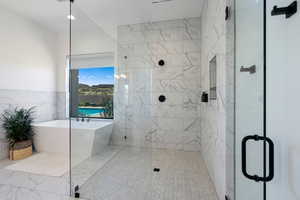 Bathroom featuring independent shower and bath and tile walls