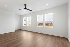 Empty room with hardwood / wood-style flooring and ceiling fan