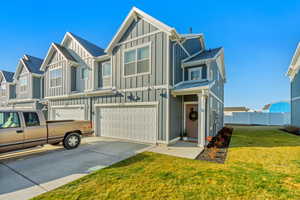 Multi unit property featuring a garage and a front yard