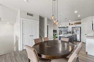 Dining room featuring sink, light wood-type flooring, and a textured ceiling