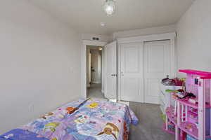 Bedroom featuring carpet flooring and a closet