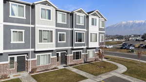 View of front of property featuring a mountain view and a front lawn