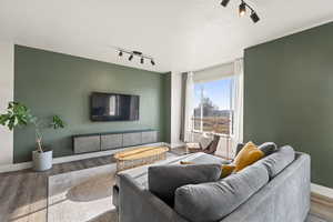 Living room with hardwood / wood-style flooring, a textured ceiling, and track lighting