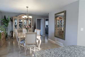 Tiled dining room featuring a chandelier