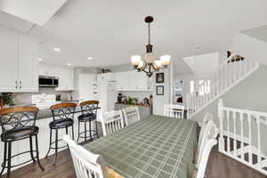 Dining room with an inviting chandelier and dark wood-type flooring