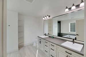 Master Ensuite Bathroom featuring hardwood / wood-style floors, vanity, a bathtub, and toilet