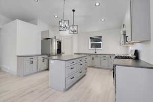 Kitchen with gray cabinets, sink, a kitchen island, and light wood-type flooring