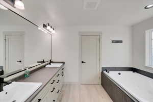 Bathroom with vanity, hardwood / wood-style flooring, and a bathtub