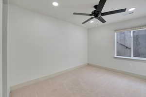 Carpeted spare room featuring ceiling fan