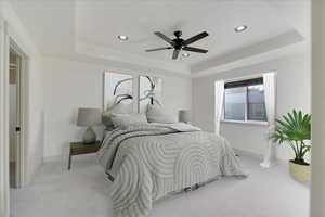 Master bedroom featuring a tray ceiling and ceiling fan