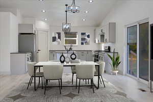 Dining room with lofted ceiling, sink, and light hardwood / wood-style flooring