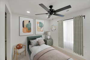 Carpeted bedroom featuring a ceiling fan