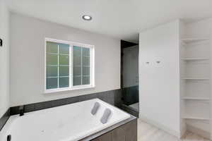 Bathroom featuring hardwood / wood-style flooring and shower with separate bathtub