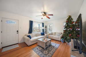 Living room with ceiling fan and light wood-type flooring