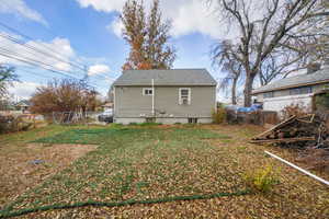 Rear view of property with a yard