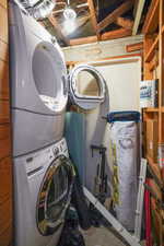 Clothes washing area featuring stacked washer and dryer