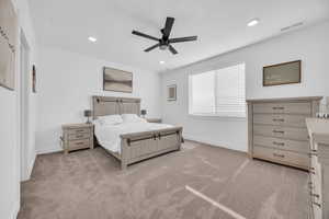 Carpeted bedroom featuring ceiling fan