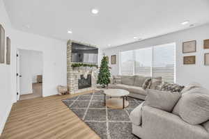 Living room with light hardwood / wood-style floors and a fireplace