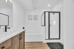 Bathroom with hardwood / wood-style floors, vanity, and independent shower and bath