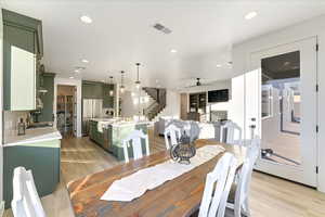 Dining room with ceiling fan, light wood-type flooring, and sink