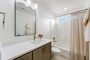 Full bathroom with tile patterned floors, vanity, toilet, and shower / tub combo with curtain