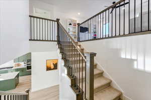 Stairway featuring hardwood / wood-style flooring