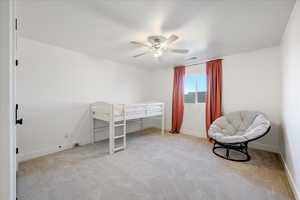 Carpeted bedroom with ceiling fan