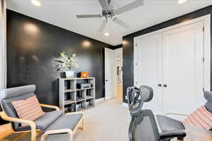 Interior space with ceiling fan and light colored carpet