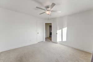 Carpeted spare room featuring ceiling fan