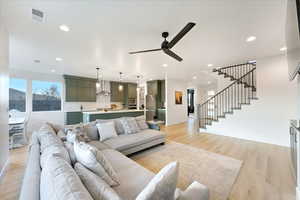 Living room featuring ceiling fan and light hardwood / wood-style flooring