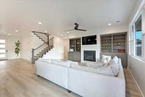 Living room featuring ceiling fan, plenty of natural light, and light hardwood / wood-style floors